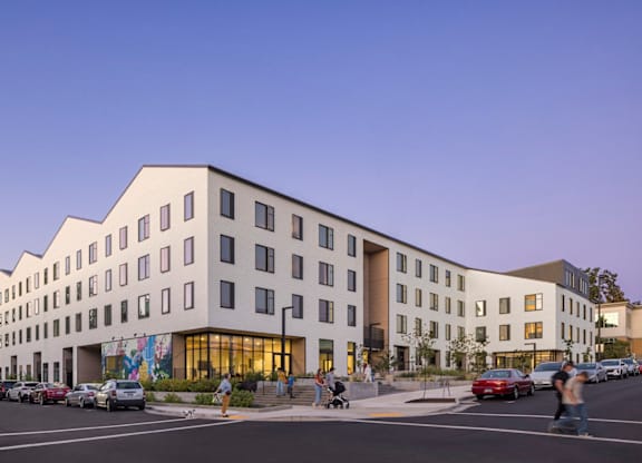 A modern building with a parking lot in front of it.