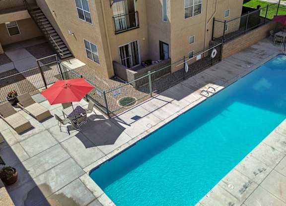 A red umbrella is next to a pool.