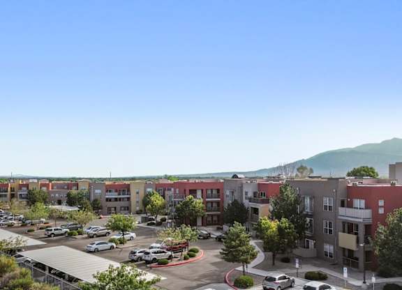 A parking lot is in the foreground of a residential area.