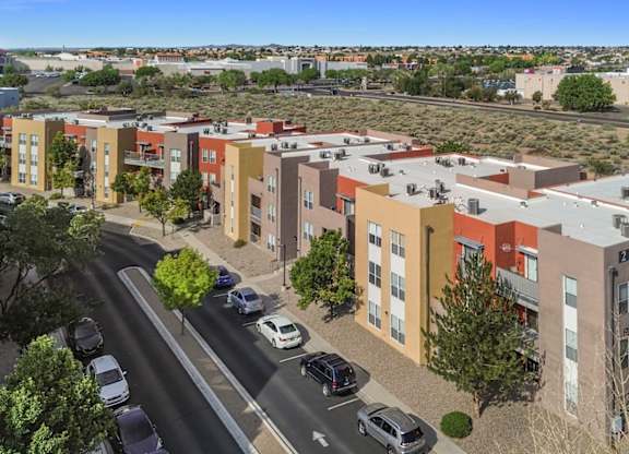 A street view of a residential area with cars and buildings.