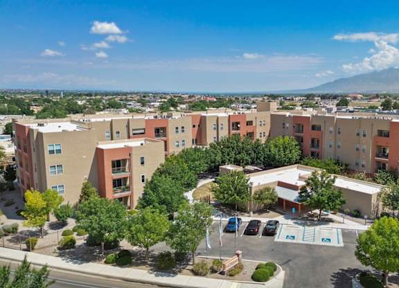 A large apartment complex with a parking lot in front.