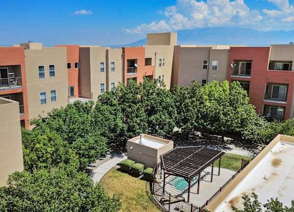 Apartment complex with a pool and trees.