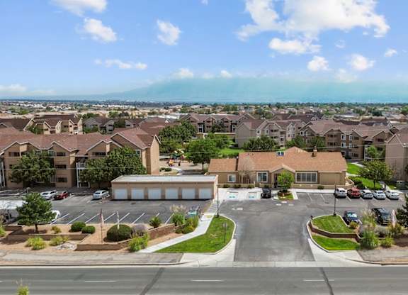 A view of a residential area with houses and a parking lot.