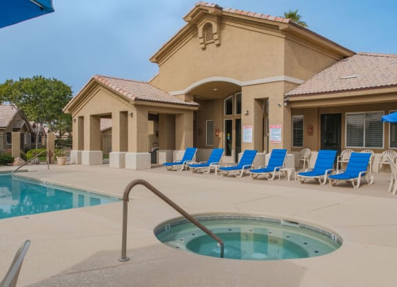 a swimming pool with blue chairs in front of a building