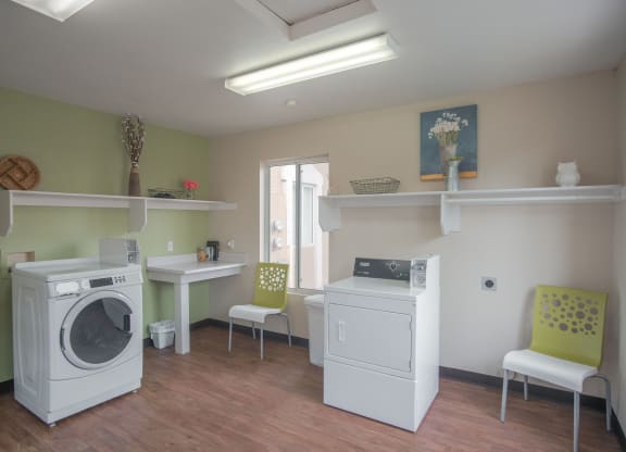 a laundry room with two washing machines and a table with chairs