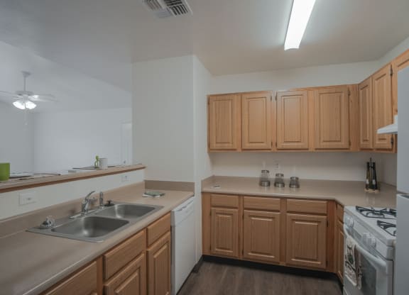 an empty kitchen with wooden cabinets and a sink