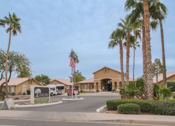a building with a sign and palm trees in front of it