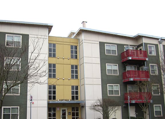 two buildings with red balconies and a yellow building in the middle