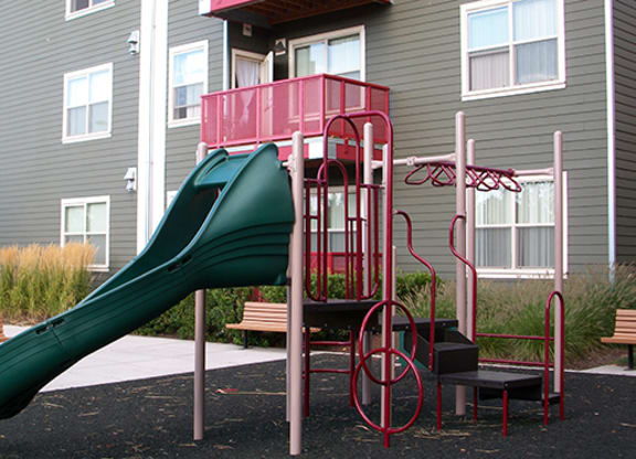 a playground with a slide in front of a building