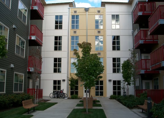 a view of the outside of an apartment building with a sidewalk and a bike