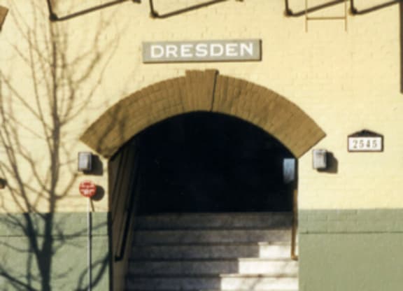 A staircase leading to a tunnel under a building with the word Dresden on it.