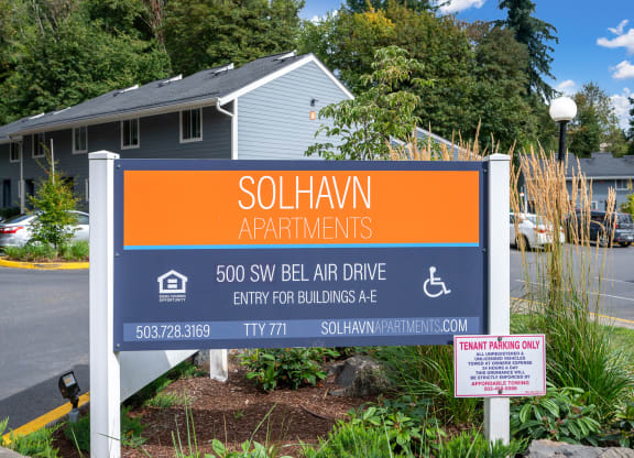 an orange and blue sign in front of a house