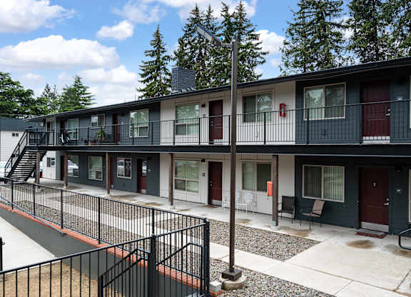 A row of modern townhouses with balconies and black railings.