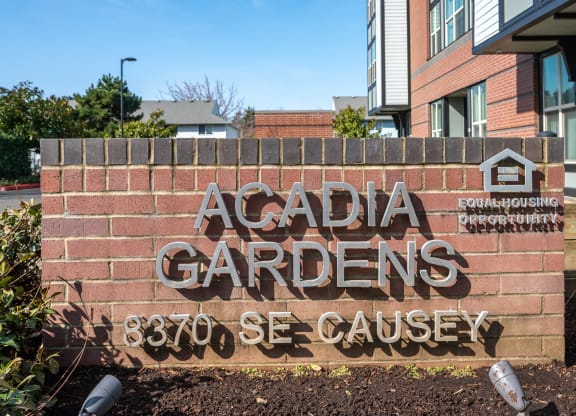 a sign for acadia gardens in front of a building