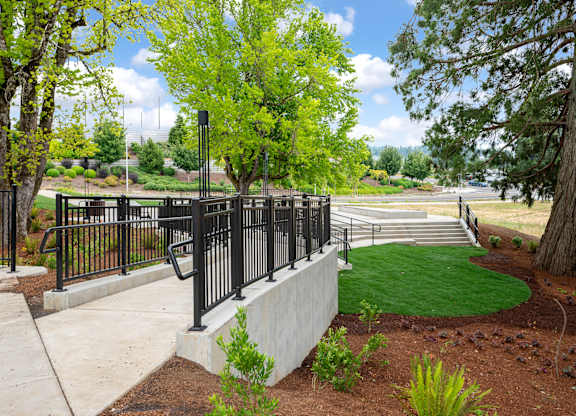 A black metal fence surrounds a green lawn.