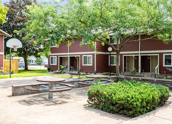 A red building with a basketball hoop in front.