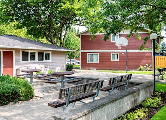 A red house with a basketball hoop in the backyard.