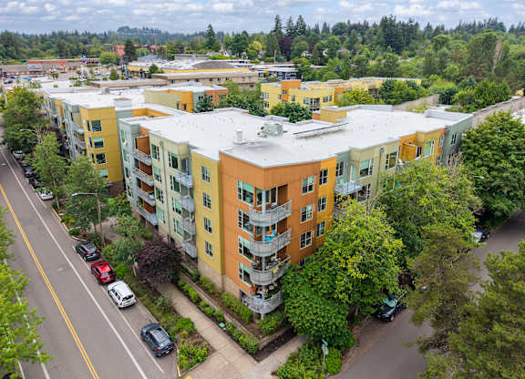 Apartment complex with cars parked in front.