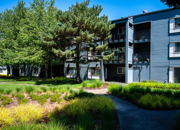 an exterior view of a building with trees and a path