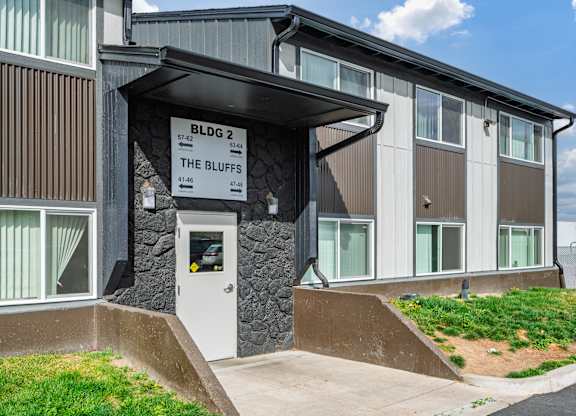 The Bluffs apartment complex has a modern design with a mix of wood and stone materials.