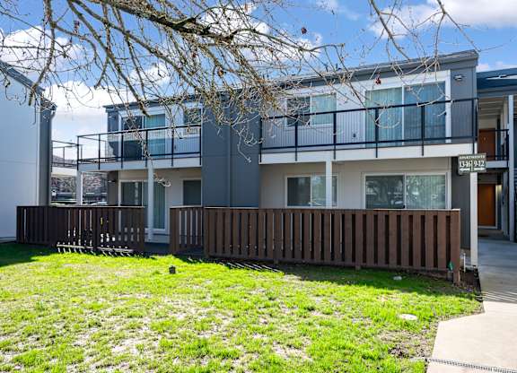A modern two-story house with a balcony and a deck.