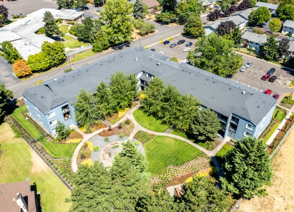 an aerial view of a building surrounded by trees and a park