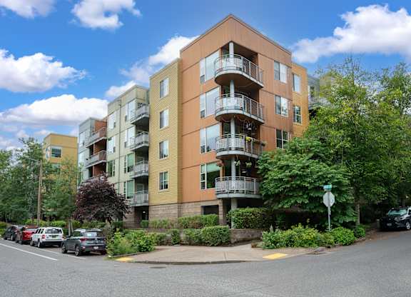 Apartment building with cars parked in front.