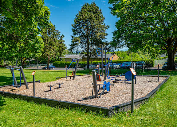 A playground with a seesaw, swings, and a slide.
