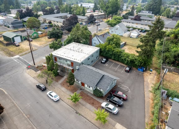 an aerial view of a building with cars parked in a parking lot