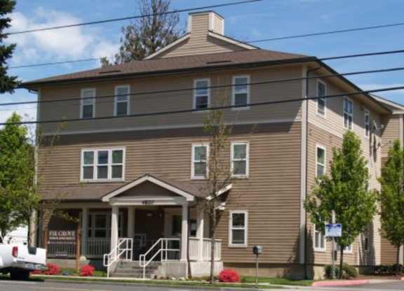 A brown building with a white truck parked in front.