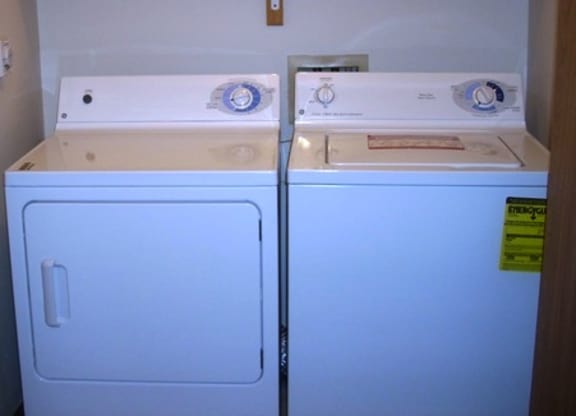 A white washing machine and dryer in a small room.
