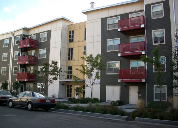 an image of an apartment building with cars parked in front