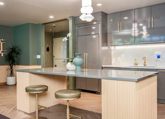 A modern kitchen with a bar stool and a counter.