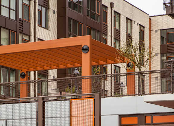 A building with a brown and white exterior and a brown awning.