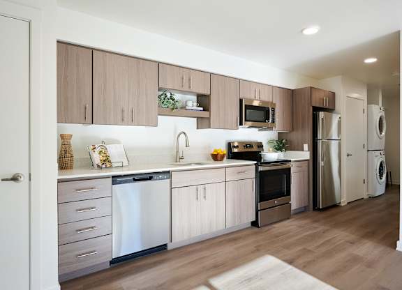 A modern kitchen with wooden cabinets and stainless steel appliances.
