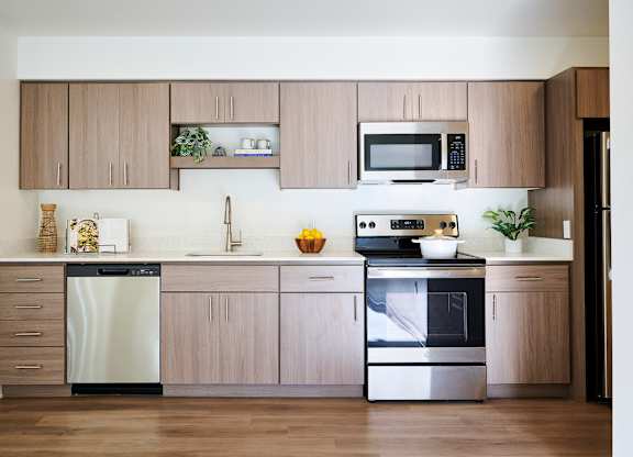 A modern kitchen with wooden cabinets and stainless steel appliances.