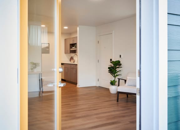 a view of a living room and a kitchen from a door