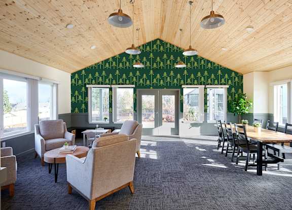 A room with a green wallpaper and wooden ceiling.