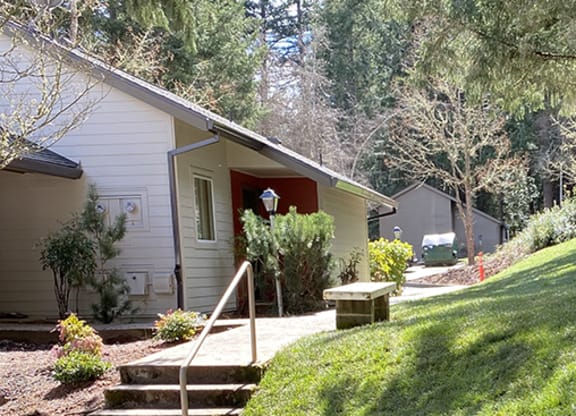 a small house on the side of a hill with a sidewalk