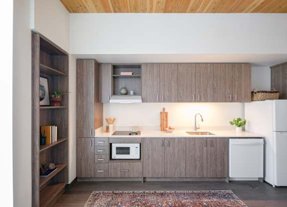 A kitchen with wooden cabinets and a white fridge.