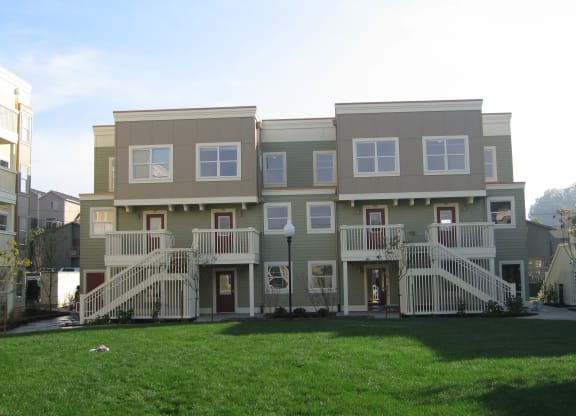 a large apartment building with a yard in front of it