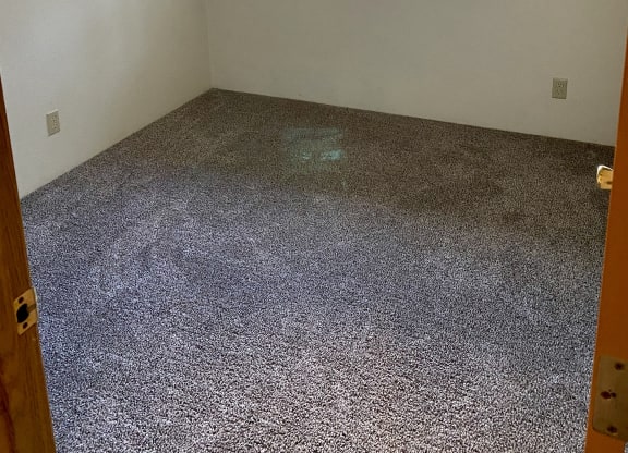 an empty room with a window and gravel floor