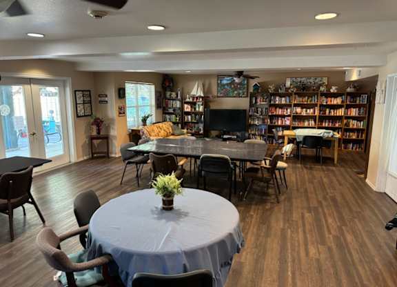 A room with a table, chairs, and a bookshelf.