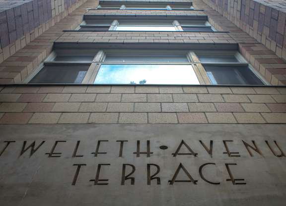 A brick wall with windows and a sign that says "Twelfth Avenue Terrace".