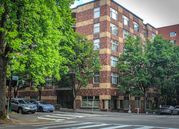 A large brick building with a parking lot in front of it.