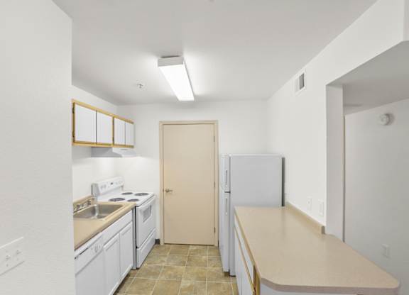 A kitchen with white cabinets and a beige countertop.