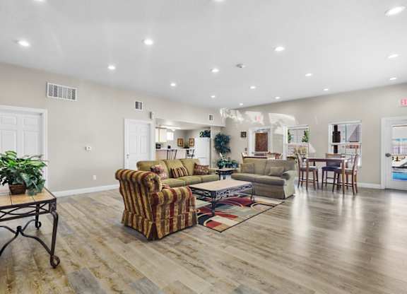 A living room with a striped couch and a wooden floor.