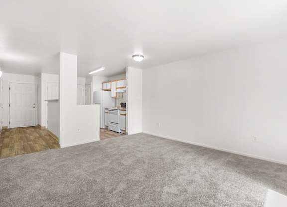 A large, empty room with a carpeted floor and white walls.