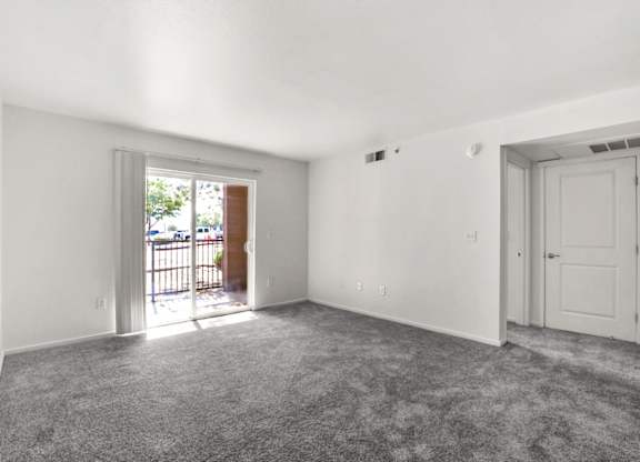 A room with a grey carpet and white walls.