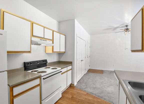 A kitchen with white cabinets and a black stove top.